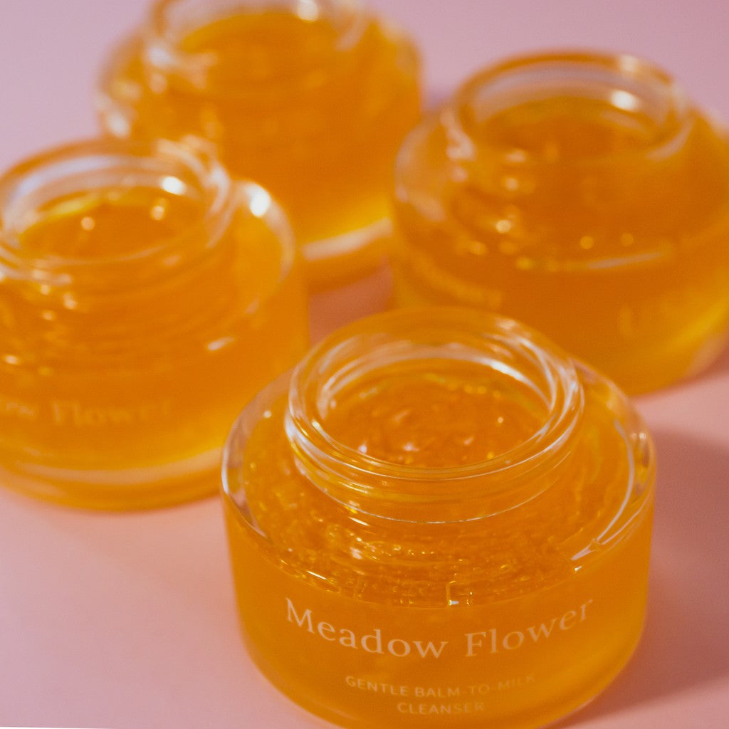 Lähikuva USVA Meadow Flower -puhdistusbalmin täyteläisestä ja hehkuvasta kultaisesta tekstuurista.